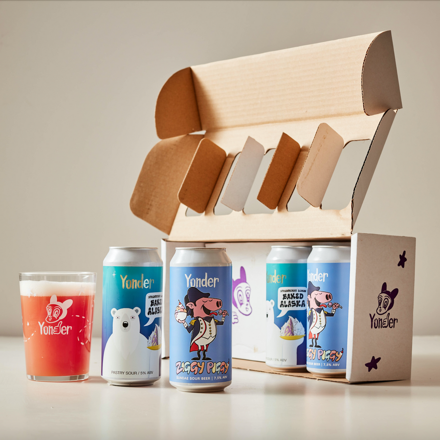 Yonder beer cans and a wooden box on a light surface with a neutral background