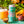 Load image into Gallery viewer, Yonder Tropical beer can with a glass of sour beer and tropical fruits on a wooden surface.

